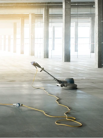 Industrial floor coating application in empty warehouse with professional equipment and power cables - Cleaning in the DC Metro area.