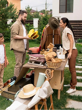 Outdoor farmers market stand with vendors and customers shopping for fresh bread and produce on grass lawn - Cleaning in the DC Metro area.