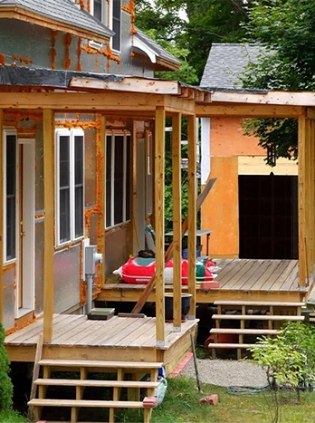 Modern tiny house with wooden deck and large windows surrounded by trees - Additions in the DC Metro area.