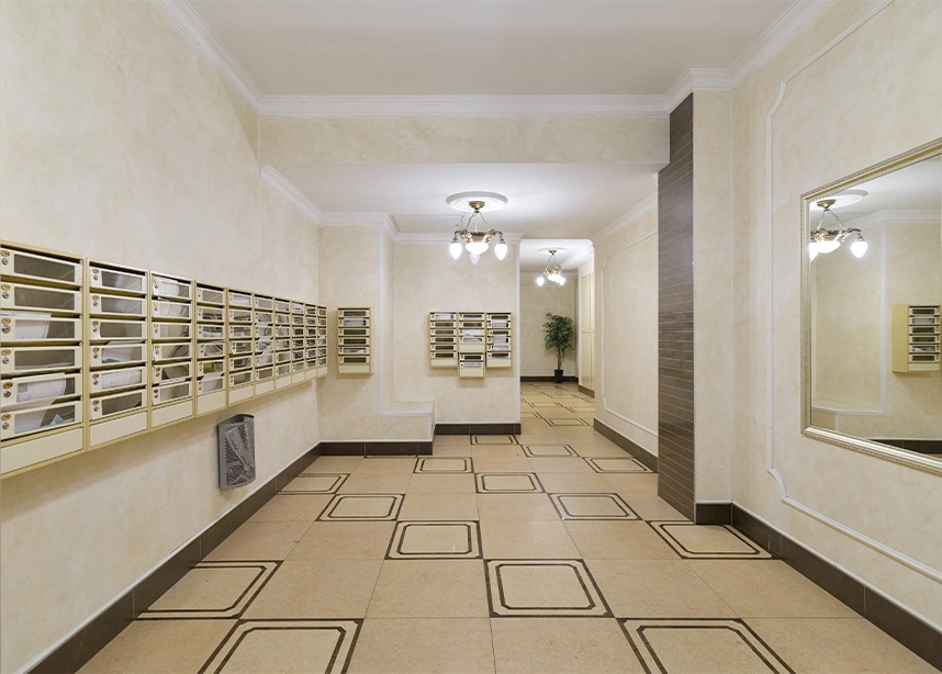 Apartment building lobby with mailboxes, tiled floor, and hallway leading to residential units - Building maitanence in the DC Metro area.