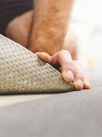 Professional installing beige carpet on floor, showing hand placement and installation technique - Carpet installation in the DC Metro area.