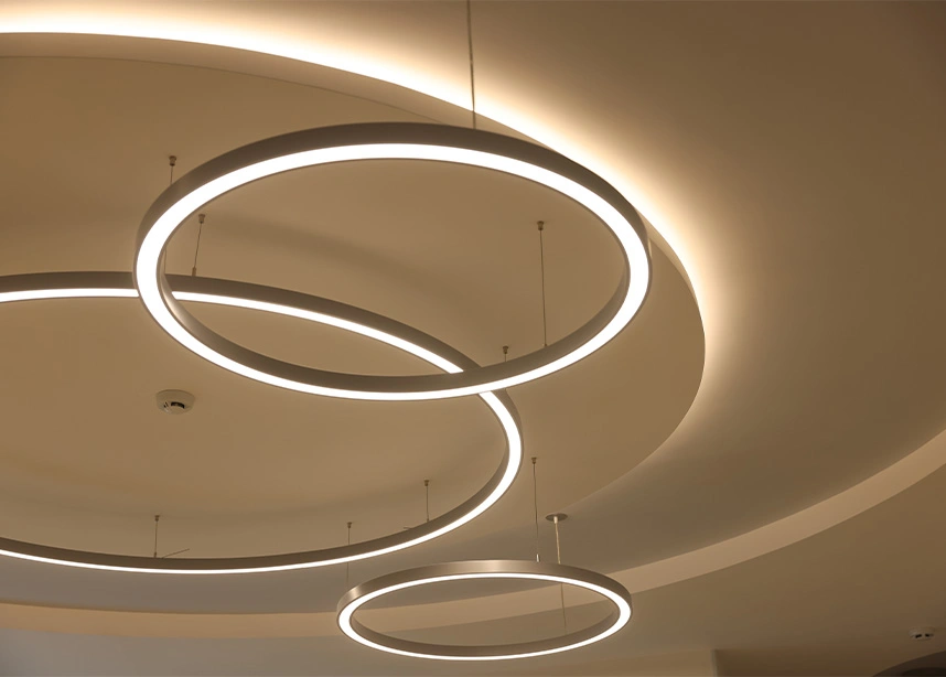 Modern circular LED pendant lights with warm glow illuminating ceiling in contemporary interior design - Eletrical work in the DC Metro area.
