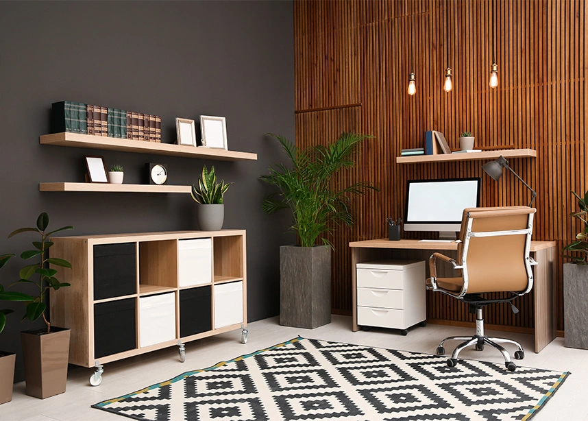 Modern home office with wooden desk, ergonomic chair, shelving units, and geometric patterned rug - In house organizing in the DC Metro area.