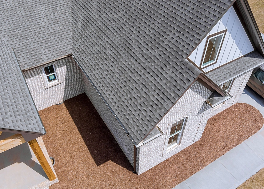Architectural model of modern house with grey roof, white walls, and dormer windows from aerial view - roofing in the DC Metro area.