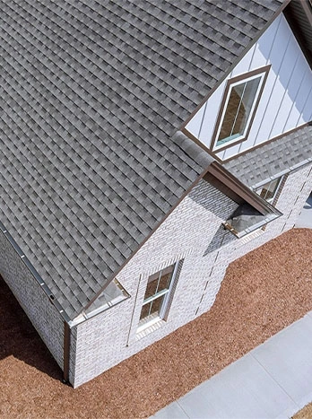 Architectural model of modern house with grey roof, white walls, and dormer windows from aerial view - roofing in the DC Metro area.